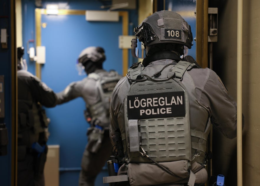 Back view of a National Icelandic Police officer in tactical uniform with ‘Logreglan Police’ on the back, standing at the remote H-2 radar site on Langanes Station, Iceland, during a training exercise.