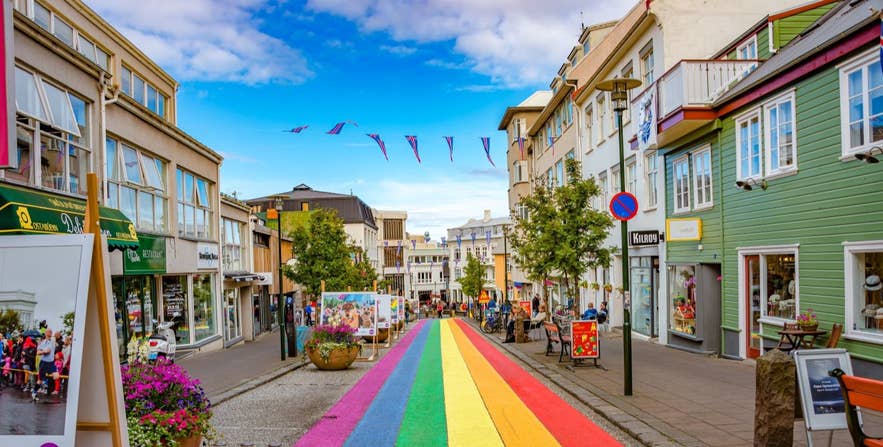Skolavordustigur rainbow street on a sunny day in Reykjavik with the Icelandic flag on banner